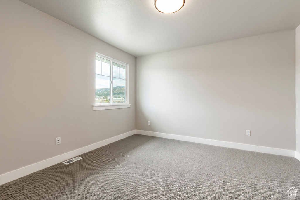 Carpeted empty room with baseboards