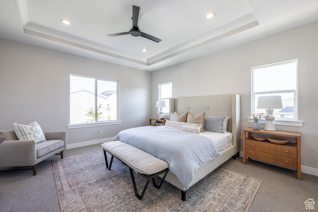Bedroom featuring a tray ceiling, light colored carpet, recessed lighting, baseboards, and ceiling fan