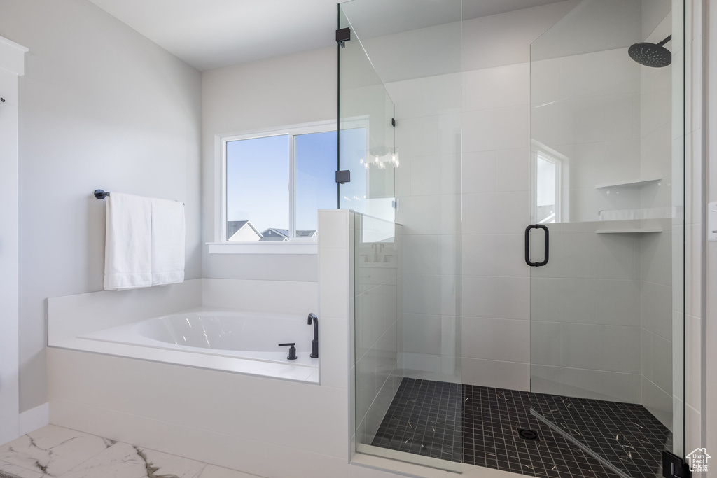 Bathroom with a bath, a shower stall, and marble look tile flooring