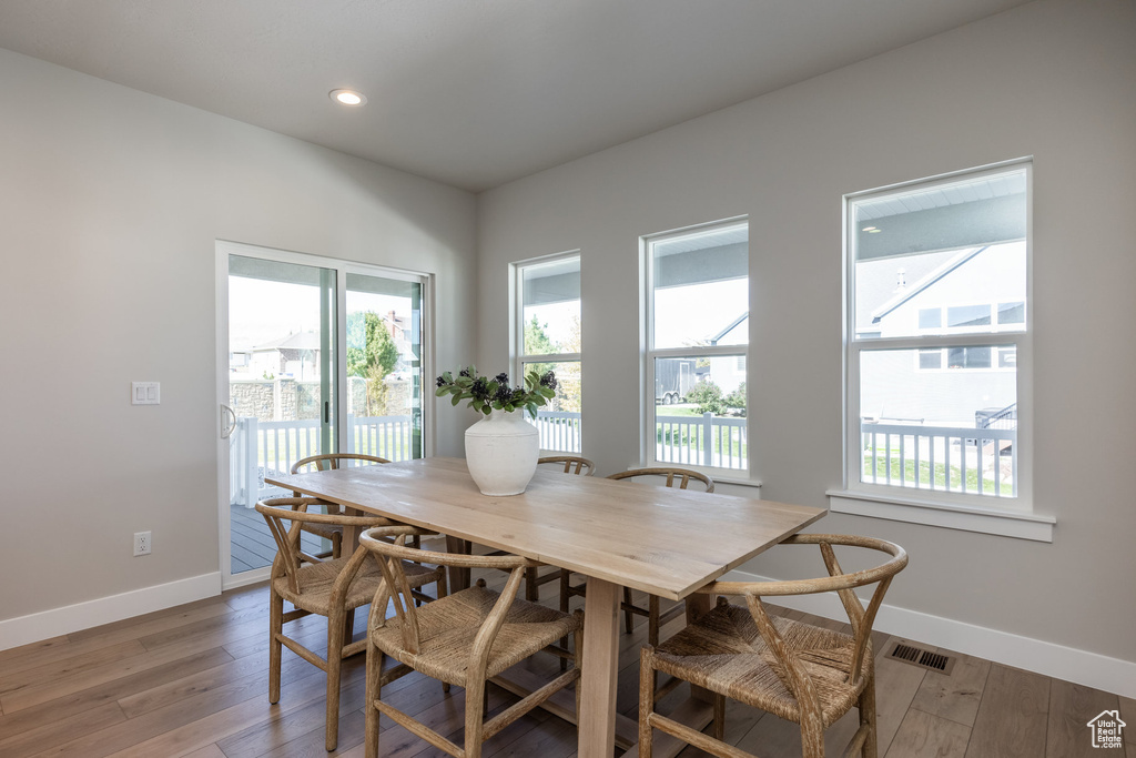 Dining room featuring baseboards, light wood-type flooring, and recessed lighting
