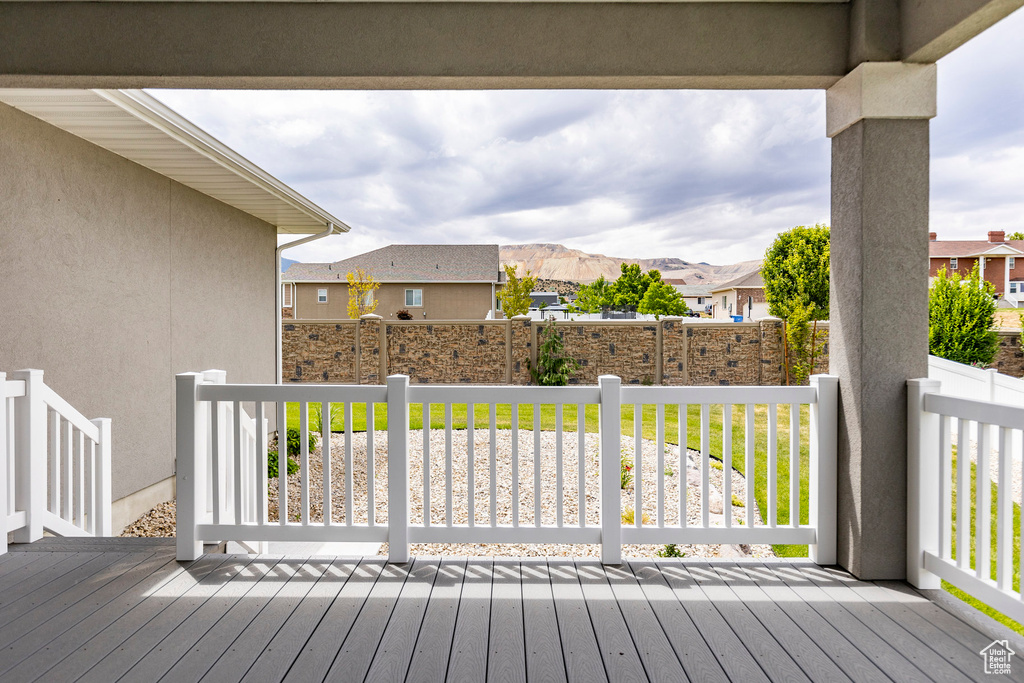 Wooden terrace featuring a residential view and fence