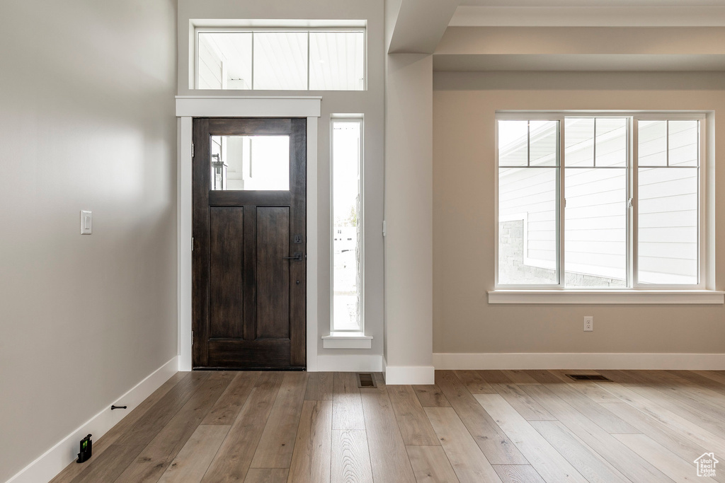 Entryway with hardwood / wood-style flooring and baseboards
