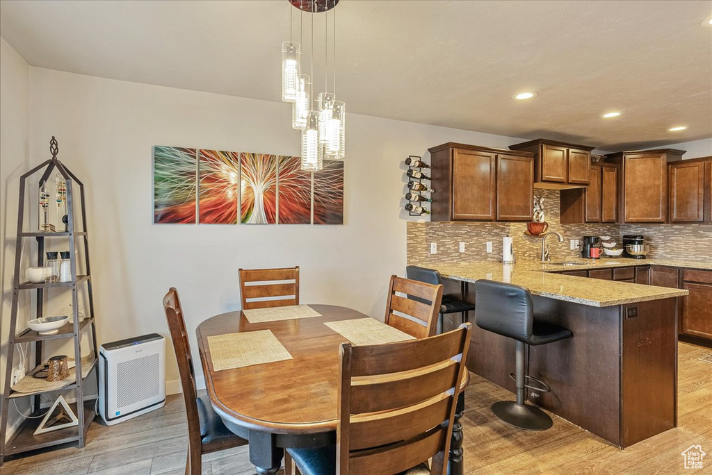 Dining space with sink and light wood-type flooring