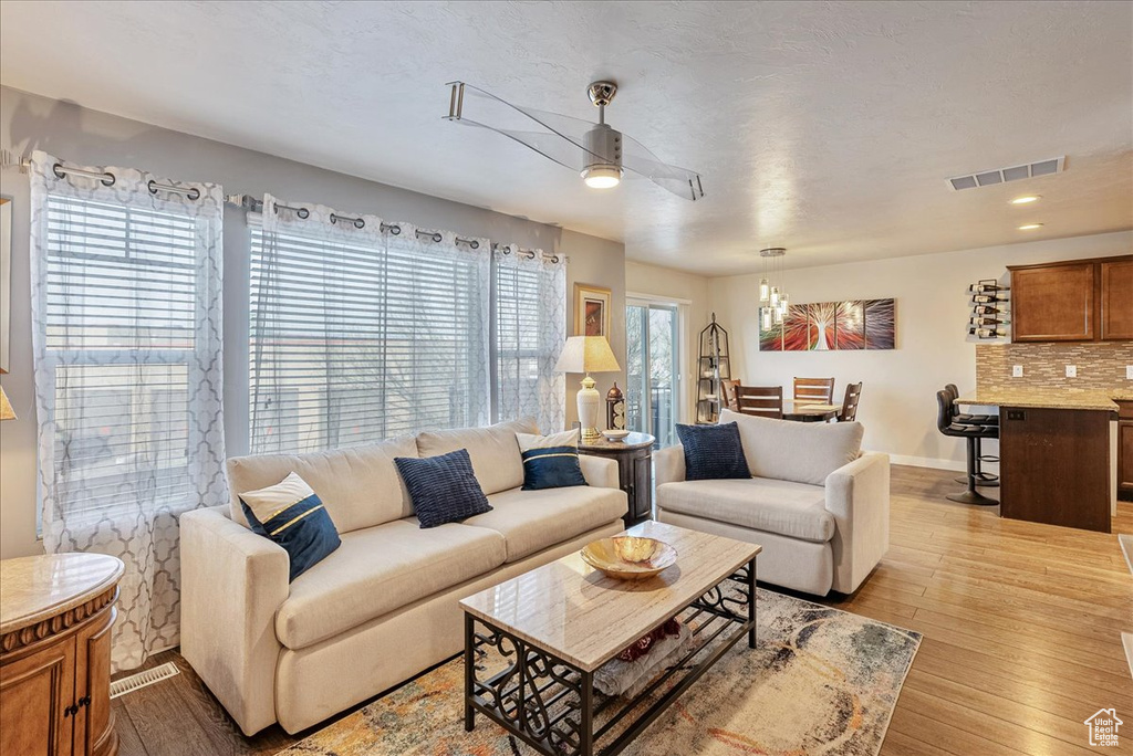 Living room featuring ceiling fan and light hardwood / wood-style flooring