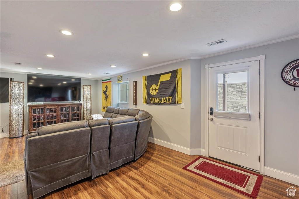 Living room with hardwood / wood-style flooring and ornamental molding