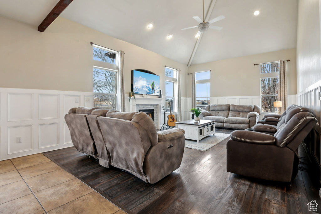 Living room with beamed ceiling, high vaulted ceiling, hardwood / wood-style floors, and a fireplace