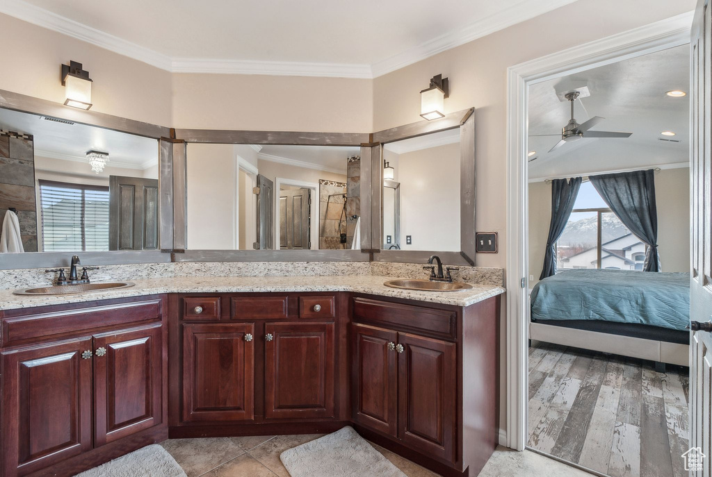 Bathroom featuring vanity, ceiling fan, crown molding, and walk in shower