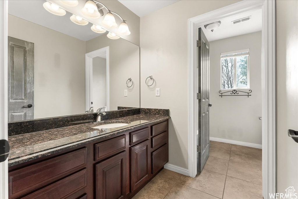 Bathroom featuring tile patterned flooring and vanity