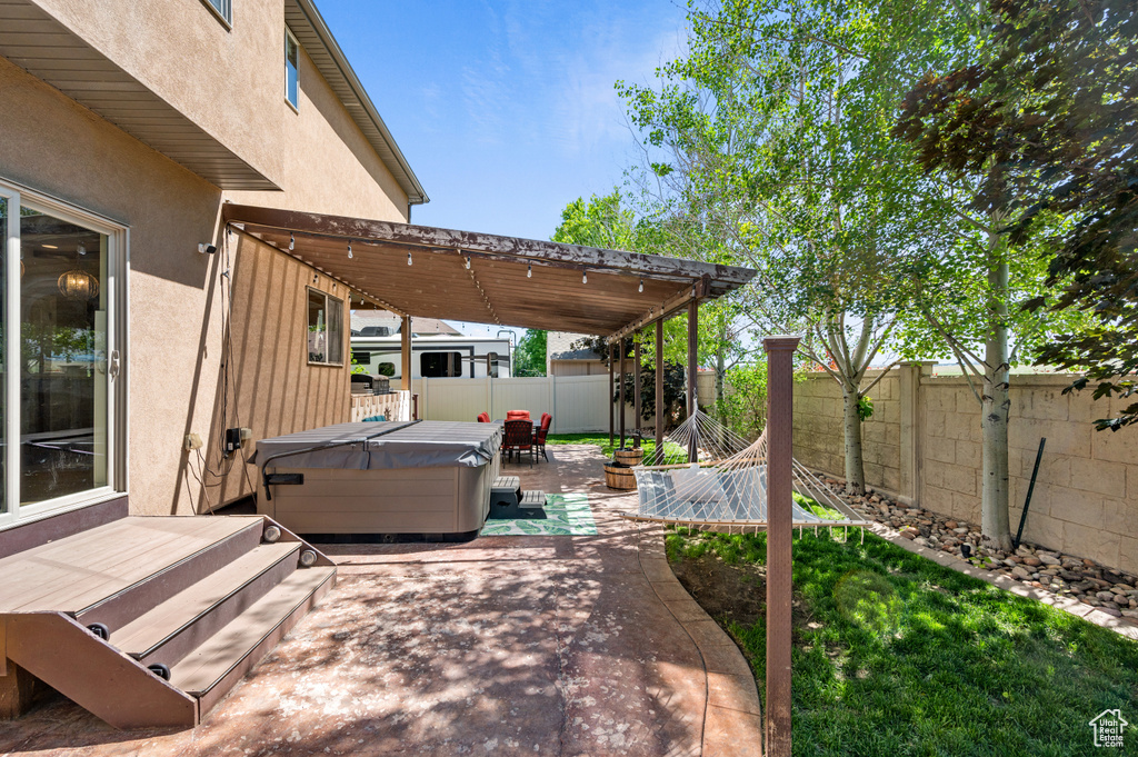 View of patio / terrace with a fenced backyard, a deck, and a hot tub