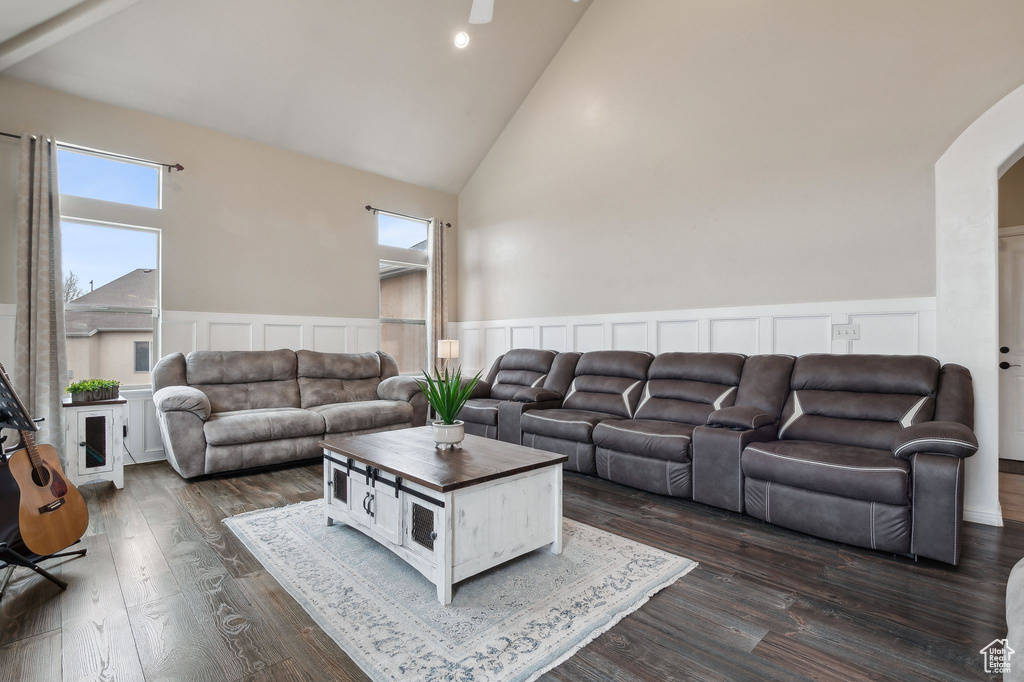Living room featuring dark wood-type flooring and high vaulted ceiling