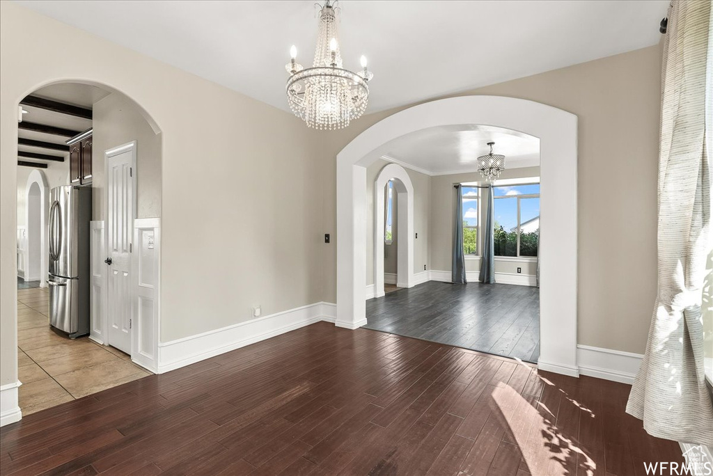 Entryway featuring hardwood / wood-style flooring, a chandelier, and beamed ceiling