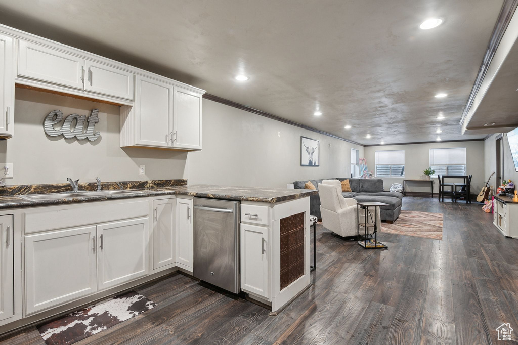 Kitchen featuring dark hardwood / wood-style floors, sink, white cabinets, and kitchen peninsula