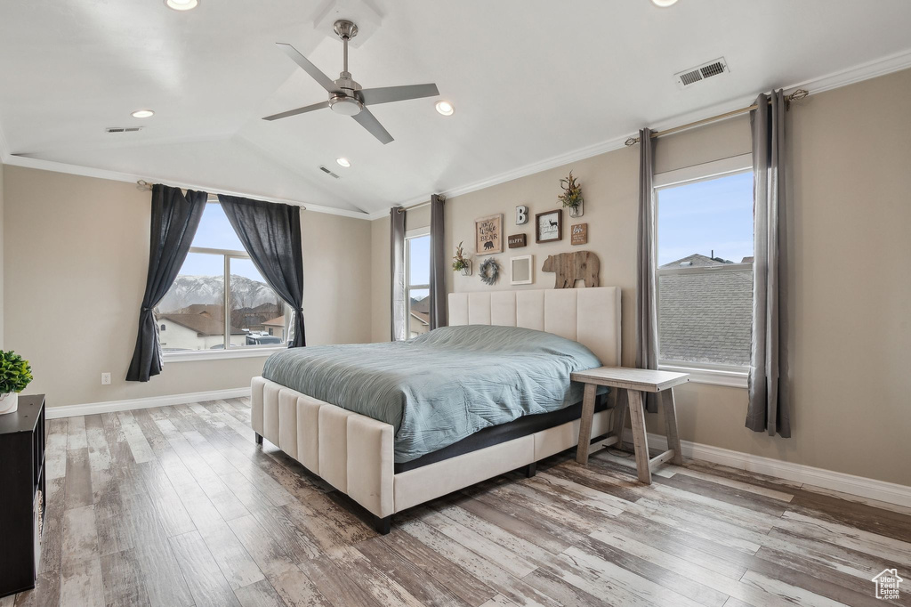 Bedroom featuring ceiling fan, ornamental molding, vaulted ceiling, and hardwood / wood-style floors