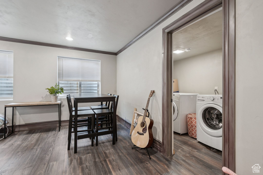 Dining room with separate washer and dryer, crown molding, and dark hardwood / wood-style flooring