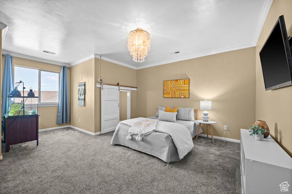 Bedroom featuring a notable chandelier, carpet floors, ornamental molding, and a barn door
