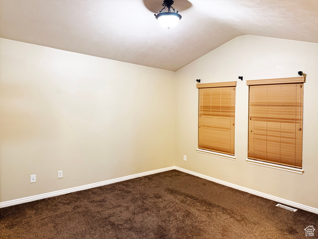 Spare room with lofted ceiling and carpet floors