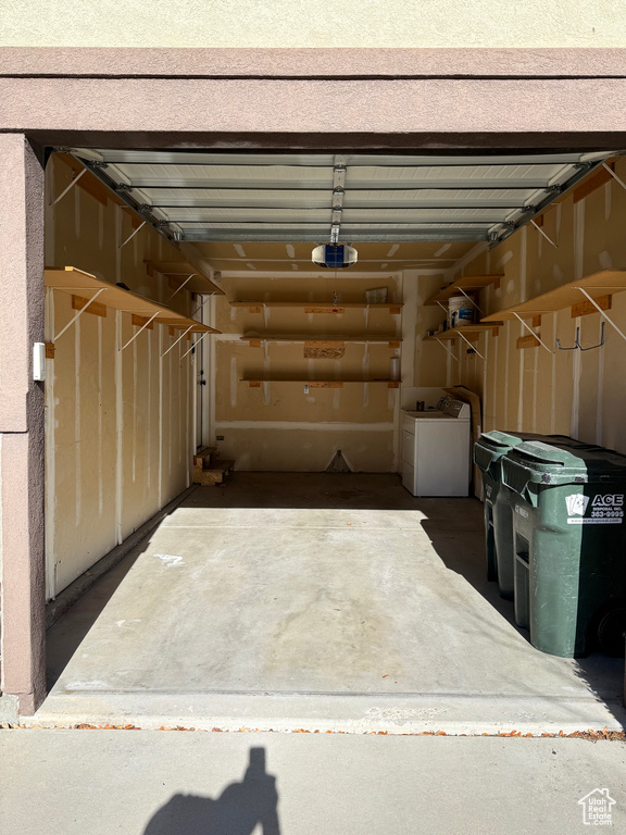 Garage featuring washer / clothes dryer and a garage door opener