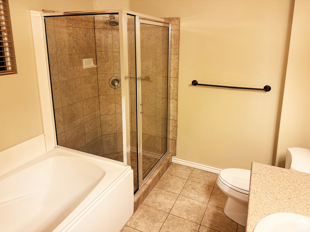 Bathroom with tile patterned flooring, separate shower and tub, and toilet