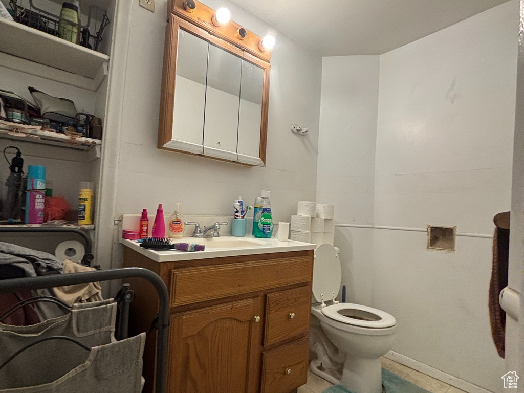 Bathroom featuring tile patterned floors, vanity, and toilet