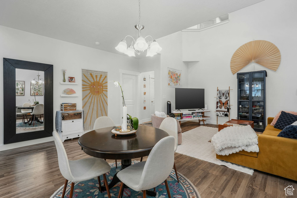 Dining area featuring a notable chandelier and dark wood-type flooring