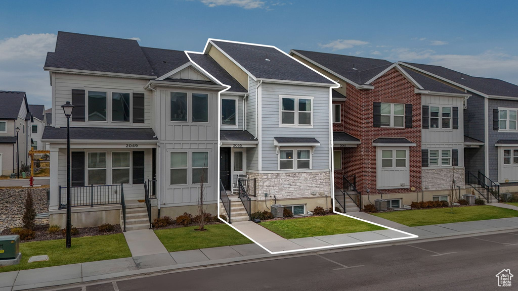 View of front facade featuring central AC unit and a front lawn