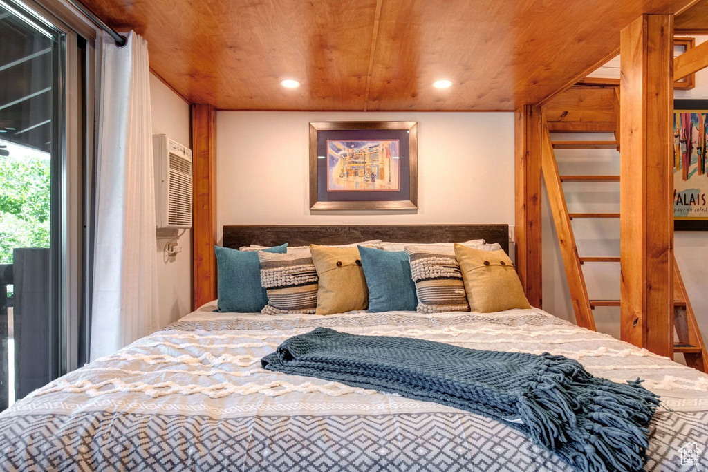 Bedroom featuring an AC wall unit, access to exterior, and wood ceiling