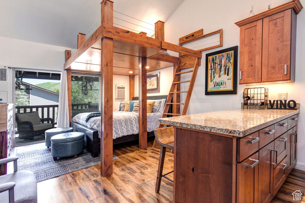 Bedroom with hardwood / wood-style floors, access to outside, and a wall mounted AC