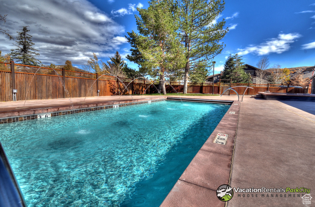View of pool featuring pool water feature and a patio