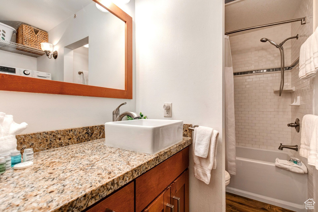Bathroom with vanity, shower / tub combo, and hardwood / wood-style floors