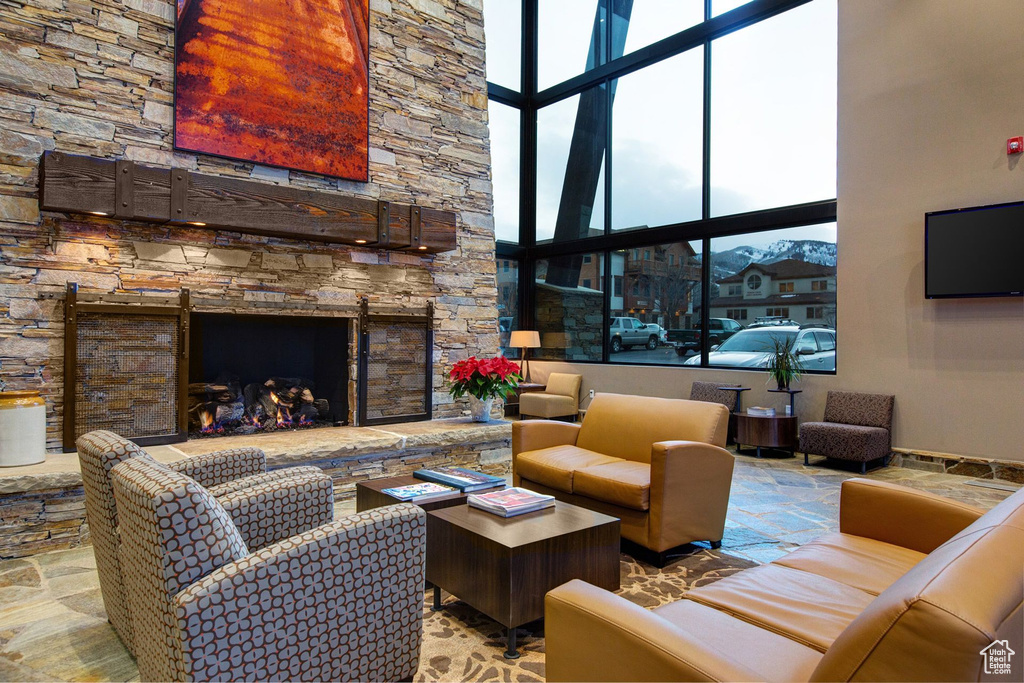 Living room featuring a stone fireplace and a high ceiling