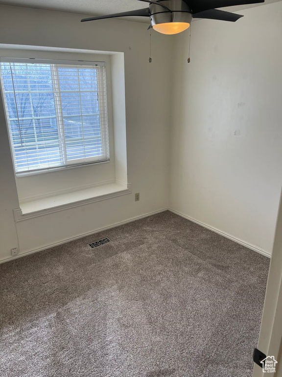 Carpeted empty room with ceiling fan