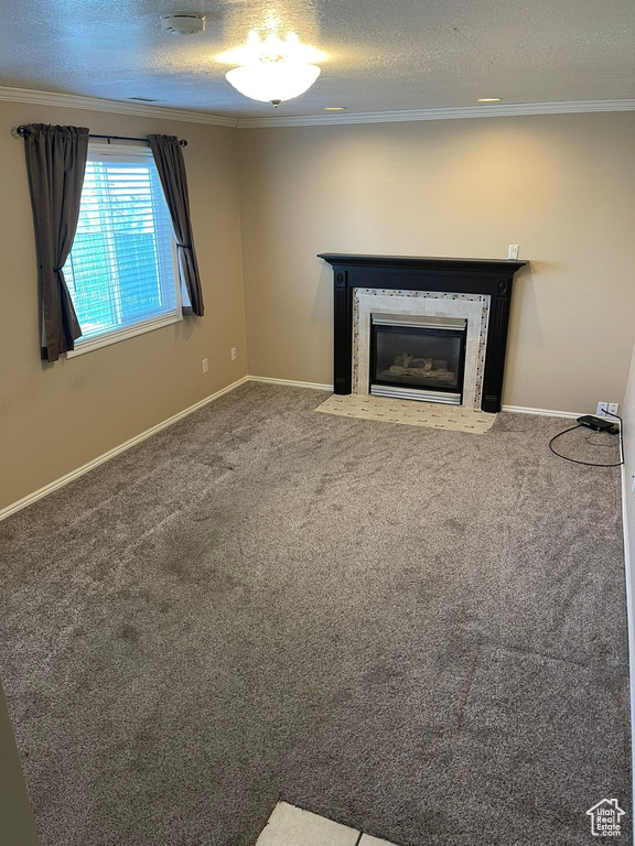 Unfurnished living room featuring ornamental molding, carpet floors, and a textured ceiling