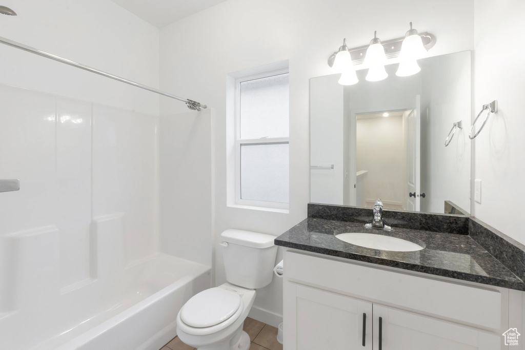 Full bathroom with vanity, tile patterned flooring, bathing tub / shower combination, and toilet