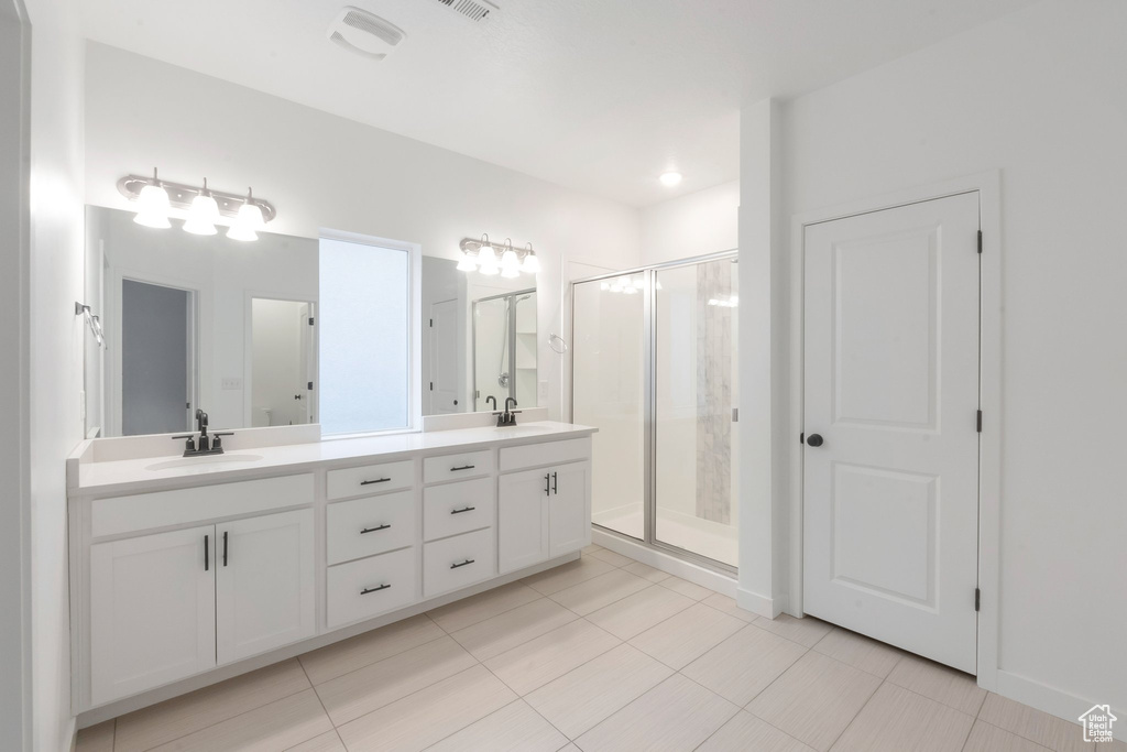 Bathroom with vanity, tile patterned flooring, and a shower with shower door