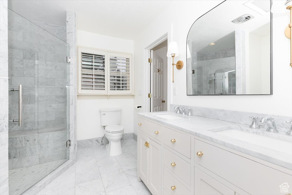 Bathroom with vanity, an enclosed shower, and toilet