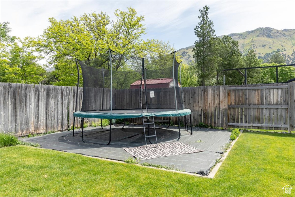 View of yard with a trampoline and a mountain view