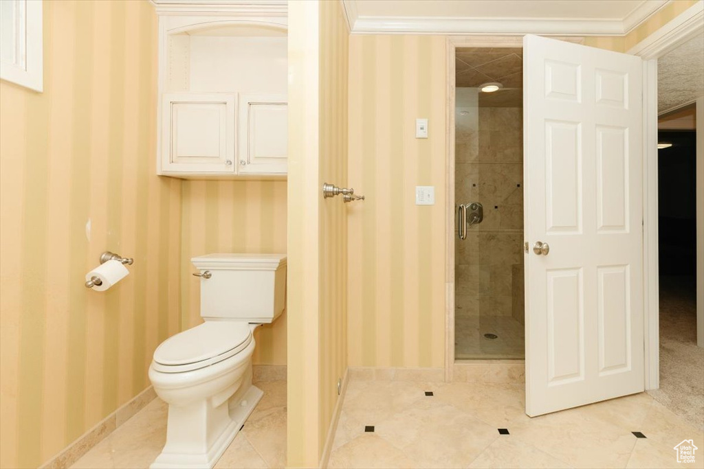 Bathroom featuring walk in shower, toilet, tile patterned flooring, and crown molding