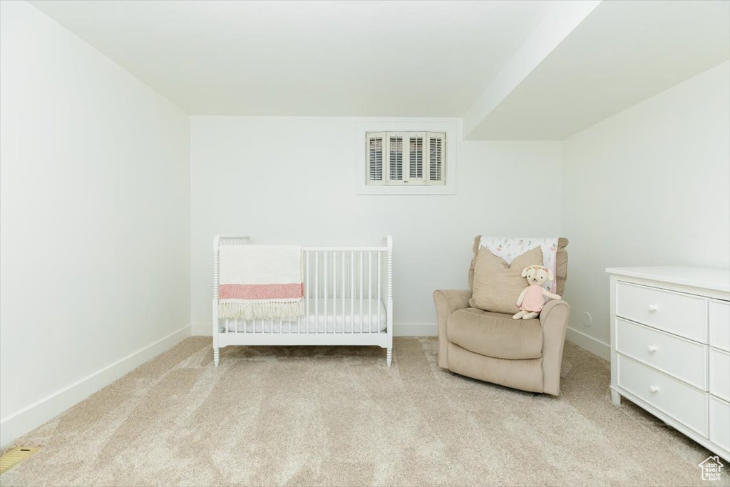 Carpeted bedroom featuring a nursery area