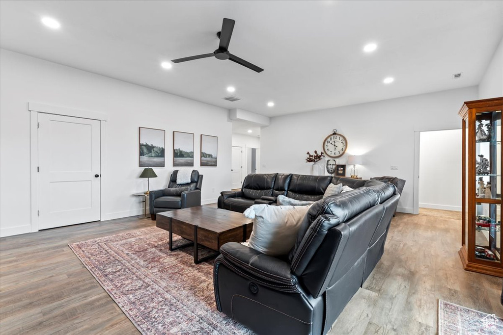 Living room with light hardwood / wood-style flooring and ceiling fan