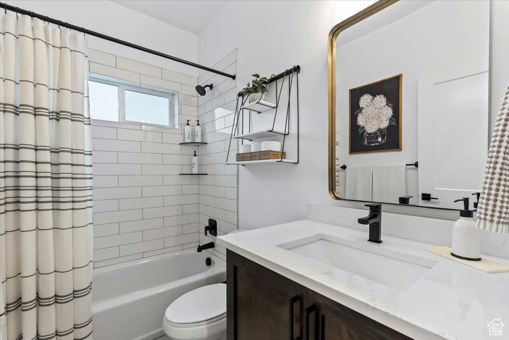 Full bathroom with vanity, toilet, and shower / bathtub combination with curtain