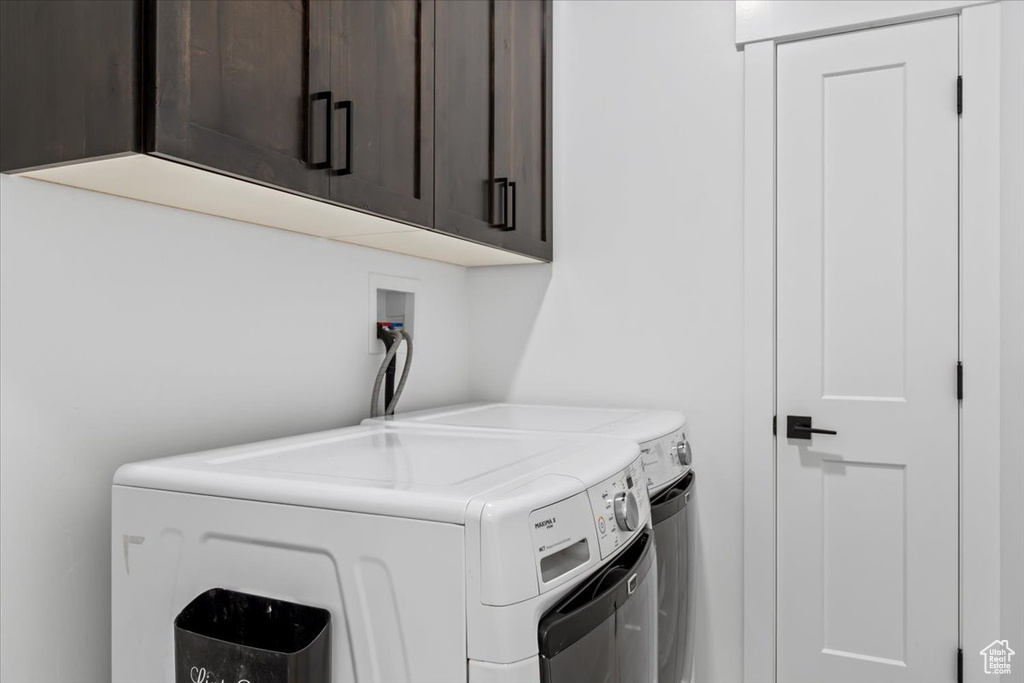 Laundry room featuring cabinets and washer and clothes dryer