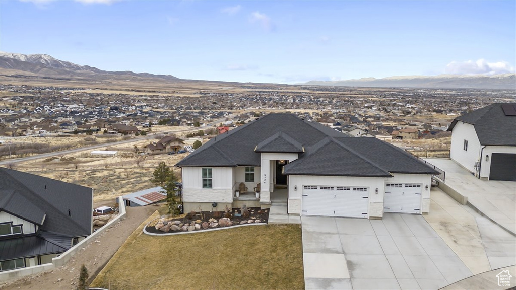 View of front of property with a garage and a mountain view