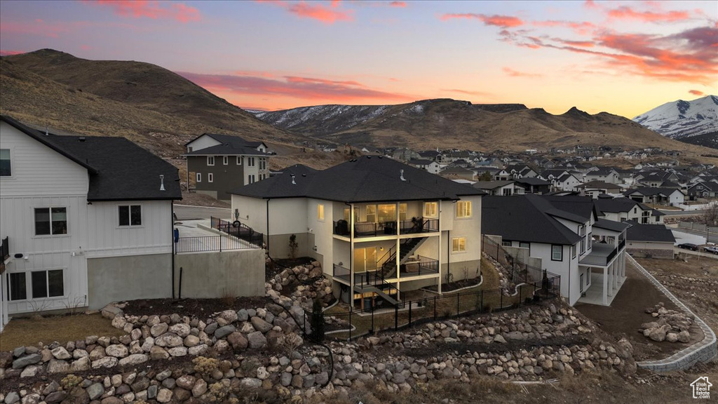 Back house at dusk featuring a mountain view