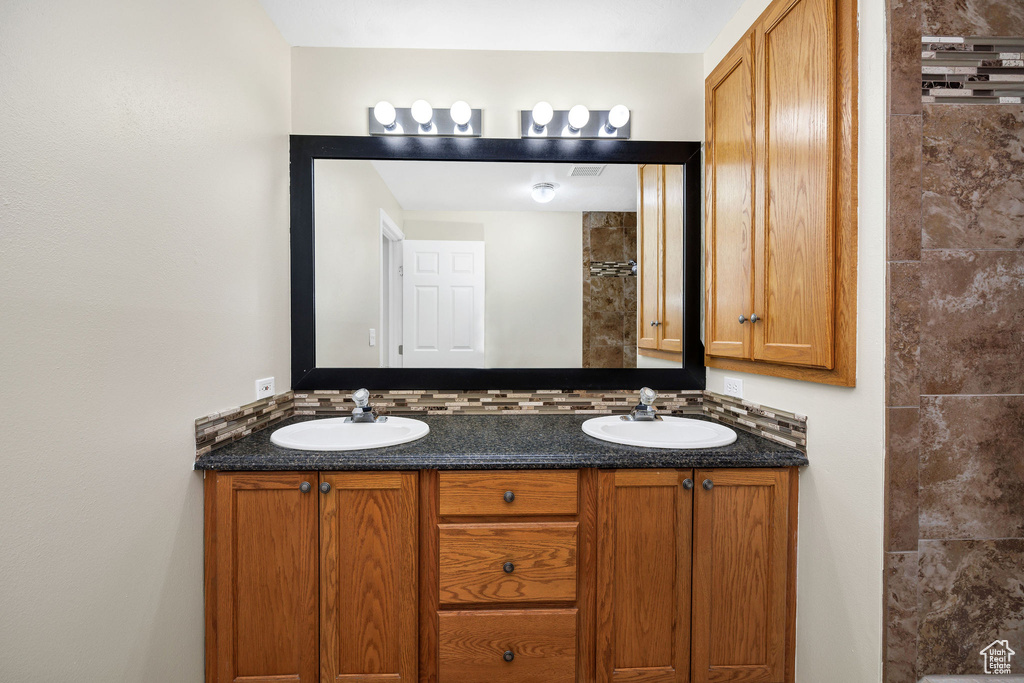 Bathroom featuring tasteful backsplash and vanity