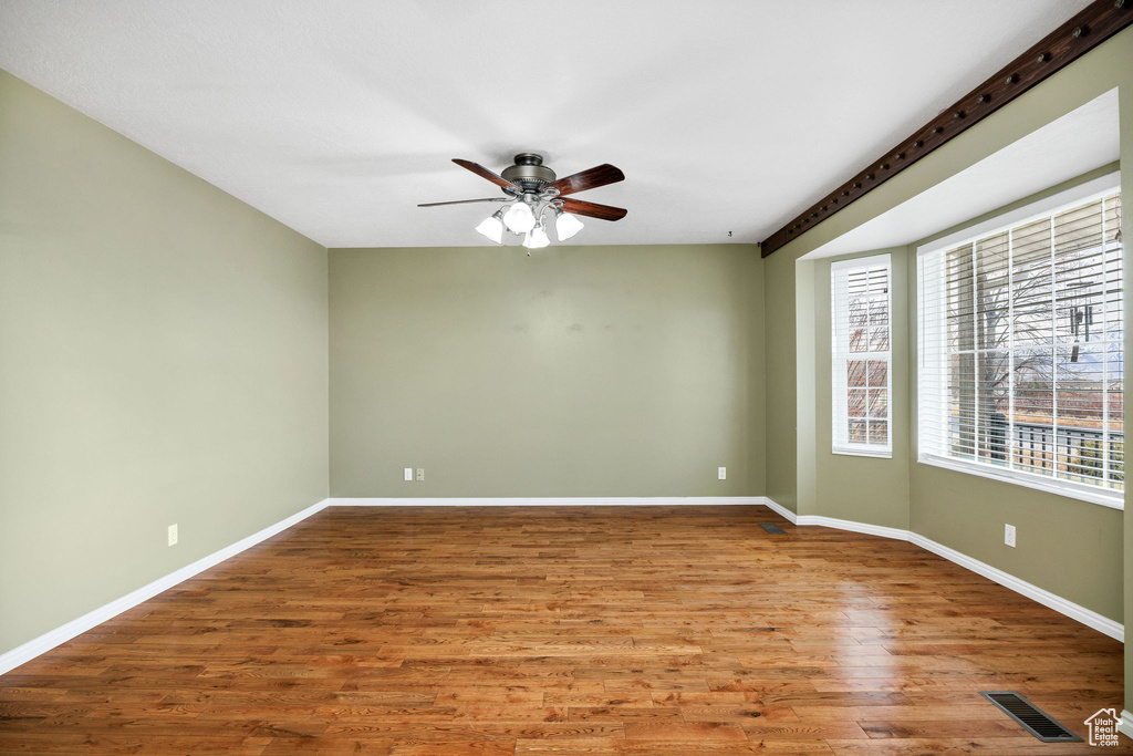 Spare room with ceiling fan and wood-type flooring