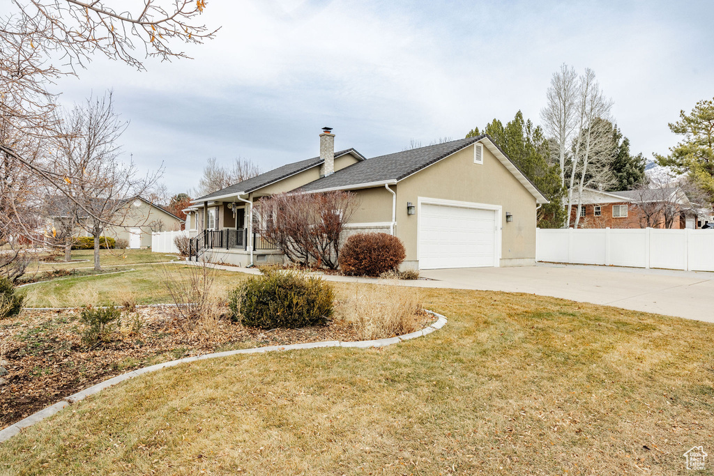 View of side of home with a garage and a lawn