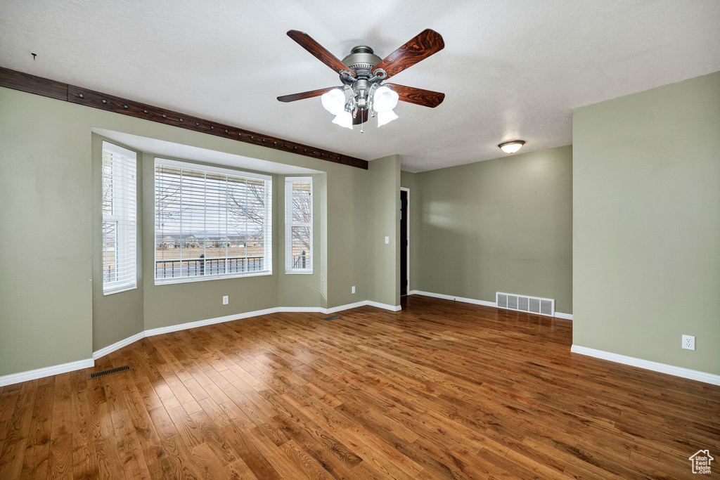 Spare room featuring dark hardwood / wood-style floors and ceiling fan