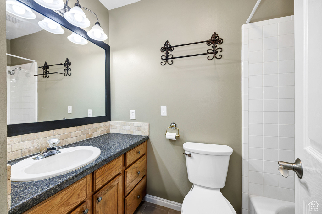 Full bathroom featuring vanity, shower / bathing tub combination, decorative backsplash, and toilet