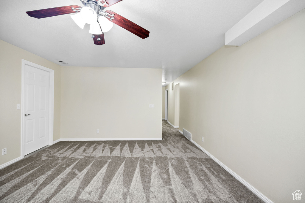 Carpeted empty room featuring ceiling fan