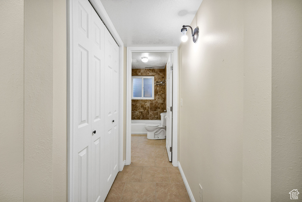 Corridor featuring light tile patterned flooring